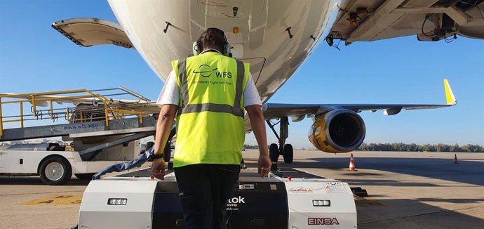 Imagen de un operario de WFS dirigiendo el nuevo pushback mientras remolca una aeronave