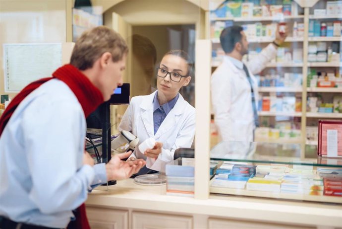 Archivo - Farmacia. Farmacia de guardia. Paciente en una farmacia. Farmacéutica atiende a un paciente.