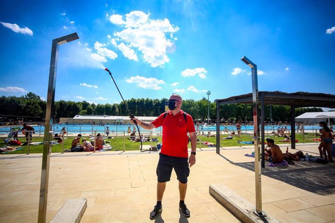 Un hombre desinfecta las duchas de la piscina del Parque Deportivo de Puerta de Hierro, el primer día de apertura de las piscinas para la temporada de verano, a 26 de junio de 2021, en Madrid (España).