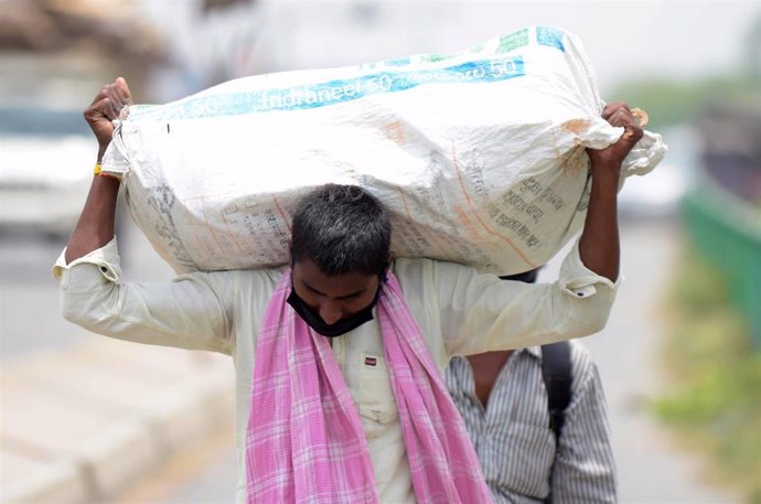Archivo - 19 May 2020, India, Prayagraj: A migrant worker carries his belongings as he walks to arrive back to his native village during a government-imposed nationwide lockdown as a preventive measure against coronavirus. Photo: Prabhat Kumar Verma/ZUM