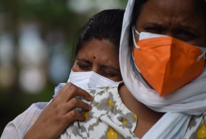 Familiares de una persona fallecida por coronavirus en India