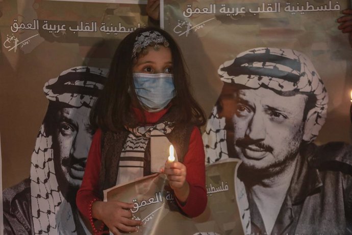Archivo - 10 November 2020, Palestinian Territories, Gaza City: A Palestinian girl holds a candle inside the home of late Palestinian political leader Yasser Arafat in Gaza City during a ceremony to commemorate the 16th anniversary of the death of the l