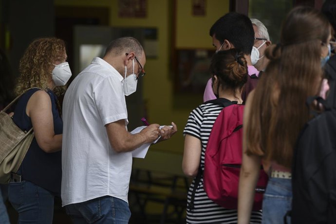Un home apunta el nom dels estudiants abans de realitzar els exmens de la selectivitat 2021, a Valncia. 