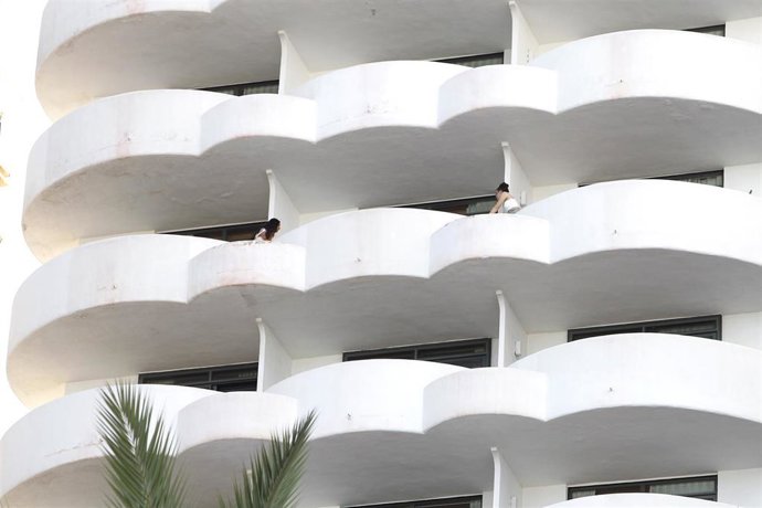 Dos jóvenes en un balcón del hotel Palma Bellver, donde estaban confinados 249 jóvenes que han tenido relación directa o indirecta con el brote de un viaje de estudios a Mallorca.