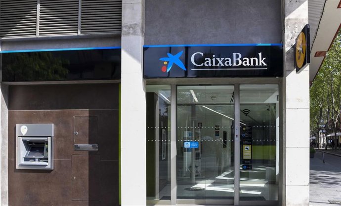 Cambio de la rotulación en una oficina de Bankia, ahora de CaixaBank.