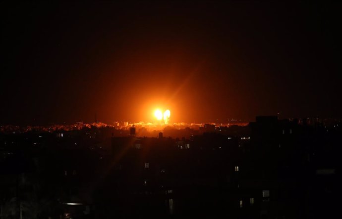 17 June 2021, Palestinian Territories, Gaza City: Explosions light-up the night sky above buildings in Gaza City as Israeli forces shell the Palestinian enclave. The Israeli military tweeted on Thursday night that the bombardments of military compounds 