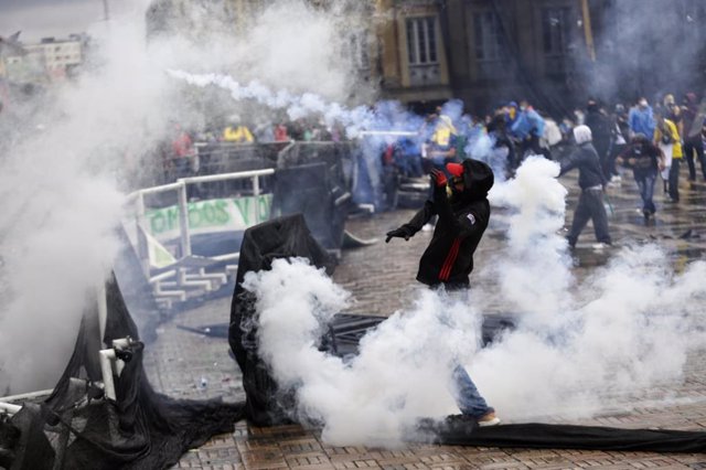 Archivo - Manifestantes en medio del humo de los botes de gas lacrimógeno durante los disturbios tras una protesta contra el Gobierno del presidente Iván Duque y la violencia policial.