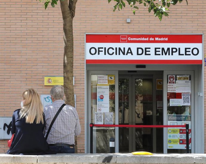 Dos personas sentadas frente a una oficina del SEPE, el día en el que se han conocido los datos de paro de mayo, a 2 de junio de 2021, en Madrid (España). 