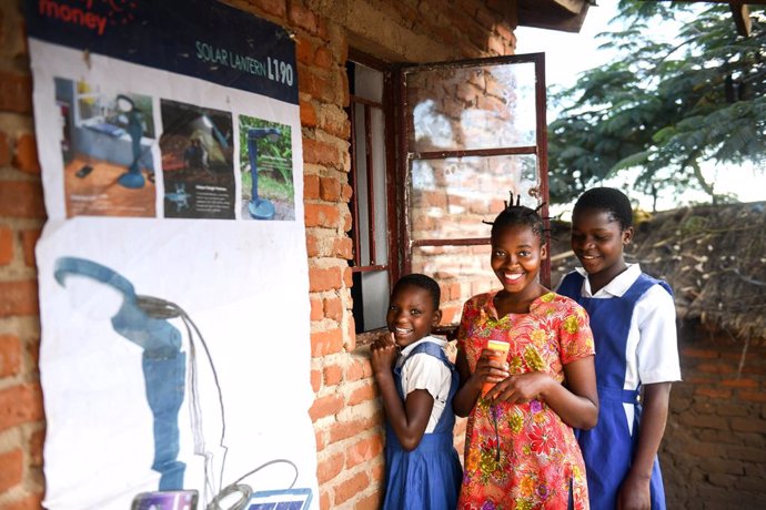 Archivo - 13-year-old Aliya Ali (right) and her friends rents a torch from Solar Money offices in Dzindebvu Village, Kasungu Central Malawi on Thursday 29 April 2021