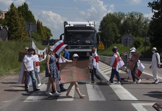 08 June 2021, Poland, Warsaw: Demonstrators wave historical Belarus opposition flags and hold placards duringa  protest at the Polish-Belarusian against the Belarusian President Alexander Lukashenko. Photo: Aleksander Kalka/ZUMA Wire/dpa