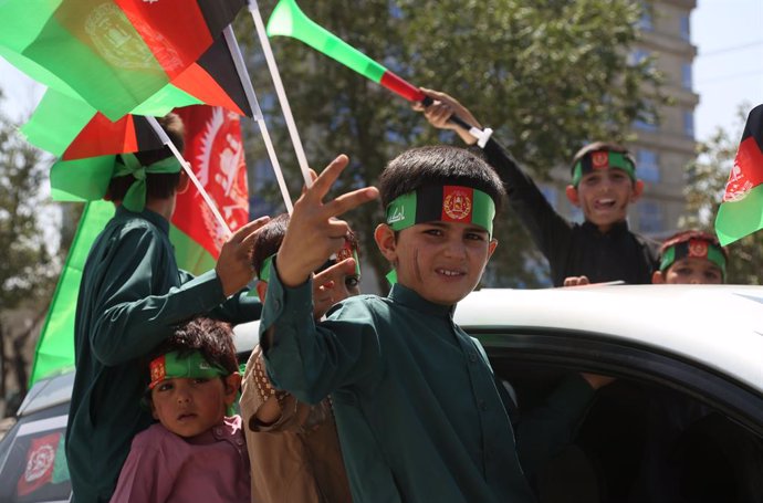 Archivo - Niños con banderas celebrando la independencia de Afganistán