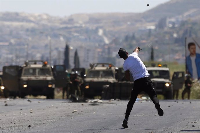 Archivo - Un manifestante palestino frente a fuerzas militares israelíes en Cisjordania