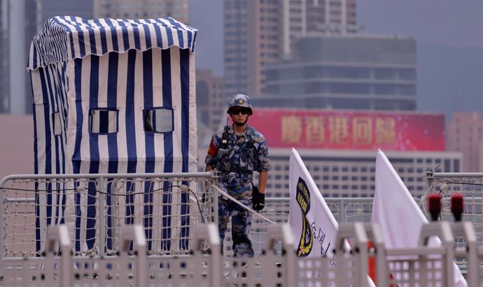 01 July 2021, China, Hong Kong: A Chinese People's Liberation Army Navy soldier stand guard on the deck of a battle ship being anchored at Admiralty Central. Today marks 24th anniversary of Hong Kong's Handover and 100th anniversary of the Chinese Commu