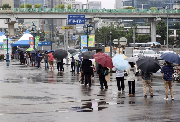 04 July 2021, South Korea, Seoul: People wait in line to be tested for the coronavirus at a temporary testing site set up outside Seoul Station. Photo: -/YNA/dpa