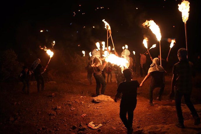 23 June 2021, Palestinian Territories, Nablus: Palestinians carry torches during a night demonstration against the expansion of a Jewish settlement on the lands of Beita village. Photo: Shadi Jarar'ah/APA Images via ZUMA Wire/dpa