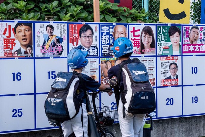 Archivo - 05 July 2020, Japan, Tokyo: Teenagers look at an election board with candidates posters during Tokyo Gubernatorial Election 2020. Photo: Viola Kam/SOPA Images via ZUMA Wire/dpa