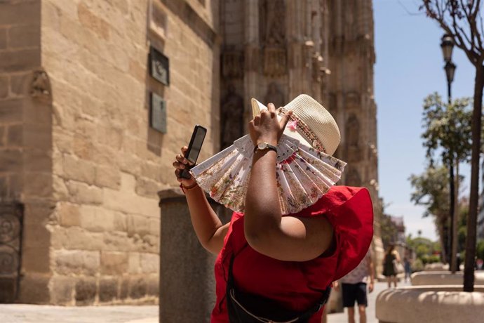 Turistas pasean por el centro de Sevilla provistos de gorras, abanicos y botellas de agua debido a que la capital andaluza ha superado los 40C y por ello se ha activado la alerta amarilla a 08 de junio del 2021, en Sevilla, Andalucía, España
