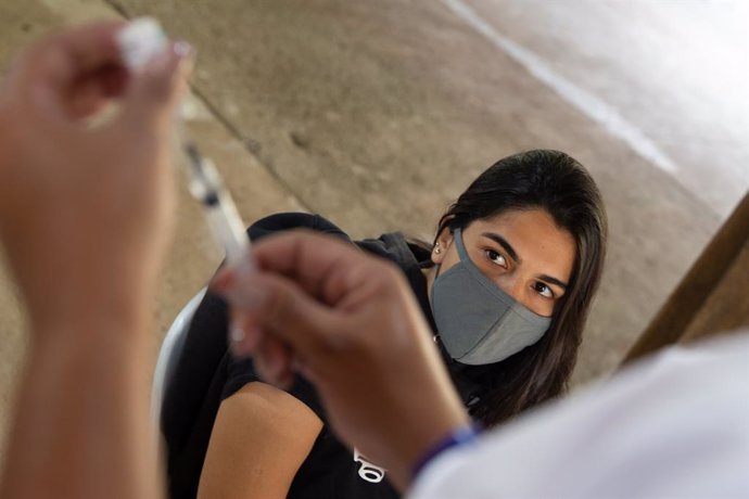 20 June 2021, Brazil, Rio de Janeiro: A medical assistant prepares to vaccinate a young woman (R) against Coronavirus (Covid-19) on the island of Ilha de Paqueta. Photo: Fernando Souza/dpa