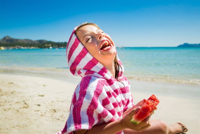 Archivo - Niña feliz, playa, verano, risa, sandía, dientes