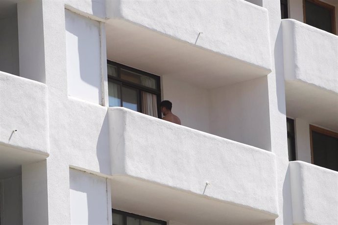 Un joven en un balcón del hotel Palma Bellver, donde estaban confinados 249 jóvenes que han tenido relación directa o indirecta con el brote de un viaje de estudios a Mallorca,