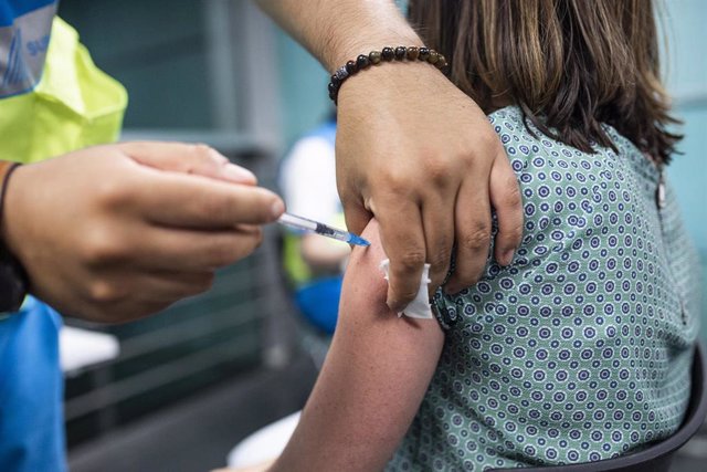 Un sanitario administra una dosis de la vacuna de Pfizer a una mujer en el Wizink Center 
