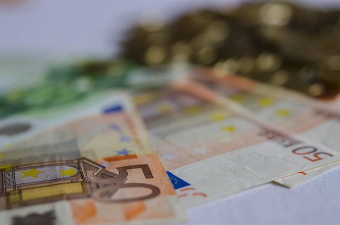 Archivo - Billetes y monedas en euros