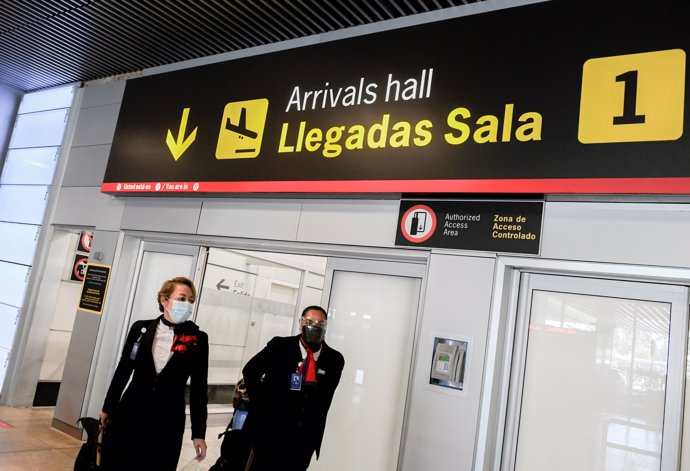 Dos azafatas llegan a la terminal T1 del Aeropuerto Adolfo Suárez Madrid-Barajas, el primer día de la primera 'Operación Salida' del verano 2021, a 2 de julio de 2021, en Madrid (España). 