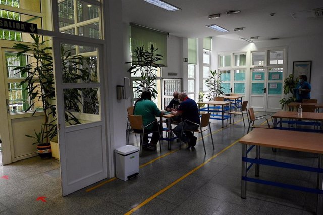 Un grupo de ancianos juega a las cartas en un centro de mayores en Madrid