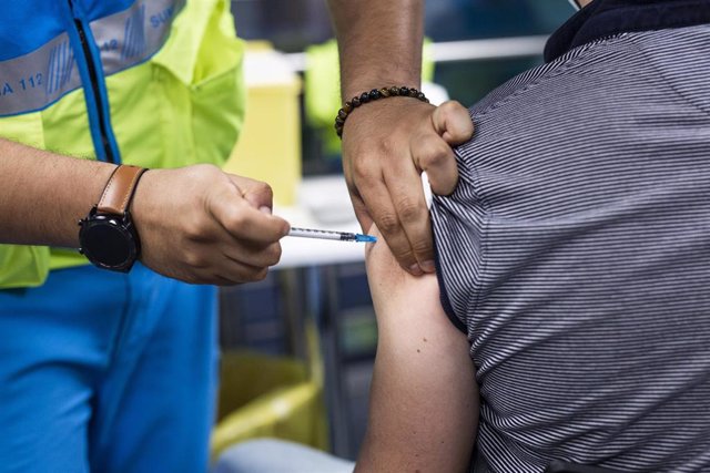 Un sanitario administra una dosis de la vacuna de Pfizer a un hombre en el Wizink Center 