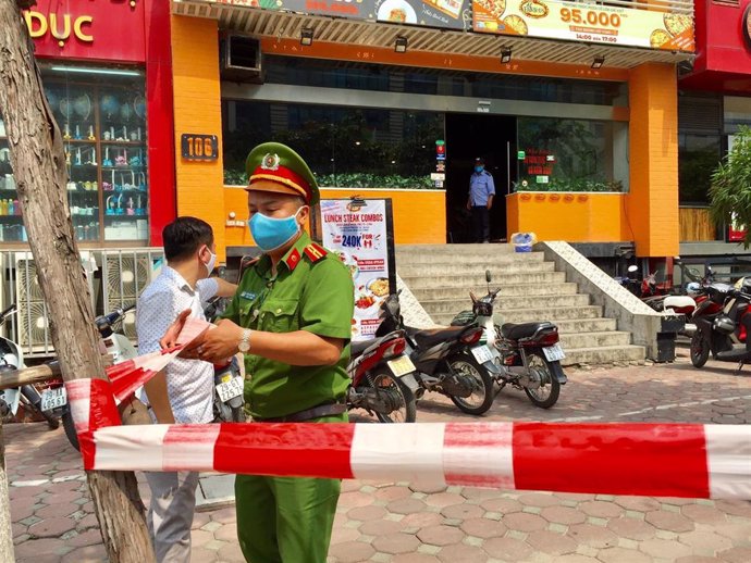 Un policía de Vietnam acordona la zona en la que se confirmó un brote de coronavirus en una pizzeria de Hanoi.