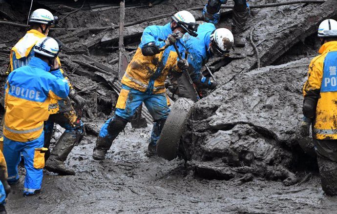 04 July 2021, Japan, Atami: Rescue workers take part in a searching operation for missing victims at the scene of a mudslide in the Japanese city of Atami. Rescuers were battling against time and the weather on Sunday in the search for about 20 people w