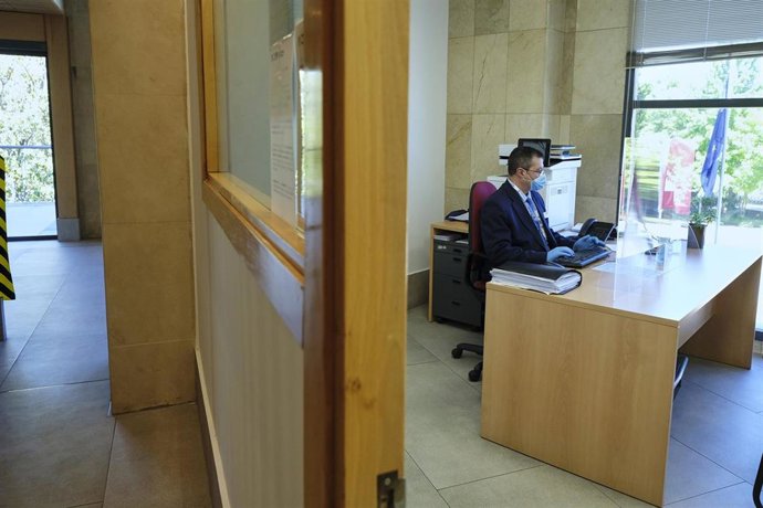 Archivo - Un trabajador protegido con guantes y mascarilla