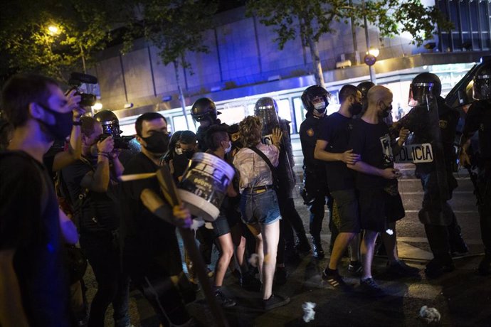 Una joven se enfrenta a antidisturbios de la Policía Nacional en el barrio de Argüelles tras la concentración por el asesinato del joven Samuel a 5 de julio de 2021 en Madrid (España). 