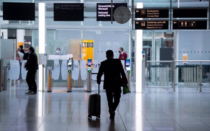 Archivo - 26 March 2021, Bavaria, Munich: A man goes to the security check with his suitcase at Munich airport. A new requirement for people arriving at German airports to have submitted to coronavirus testing has been postponed from Sunday to Tuesday. 