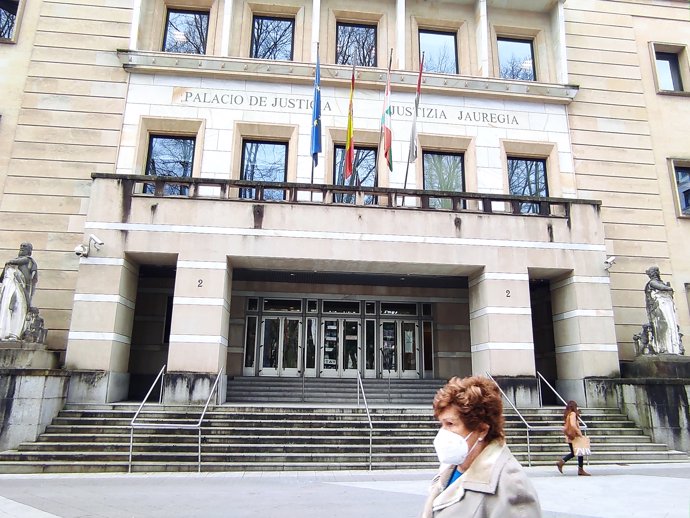 Una mujer con mascarilla pasa por delante del Tribunal Superior de Justicia del País Vasco.