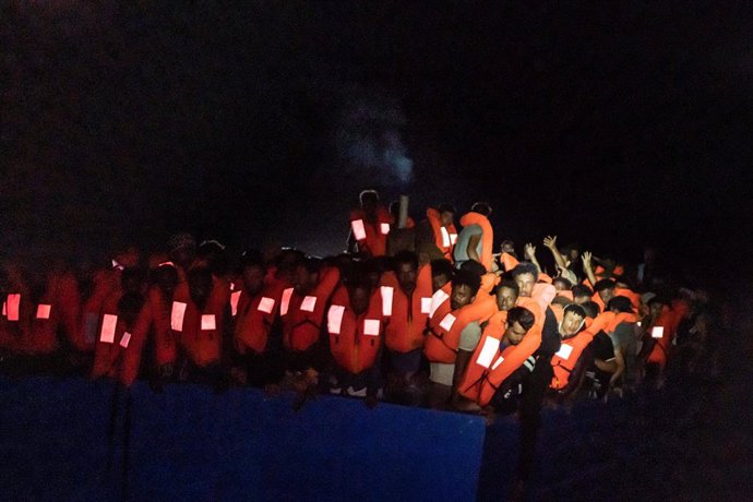 HANDOUT - 05 July 2021, ---, Mediterranean Sea: Numerous refugees are crowded together on a boat at night. The private sea rescuers of the ship Ocean Viking have rescued several hundred boat migrants in the central Mediterranean Sea in a major operation