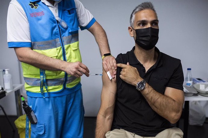 Un sanitario administra una dosis de la vacuna de Pfizer a un hombre en el Wizink Center
