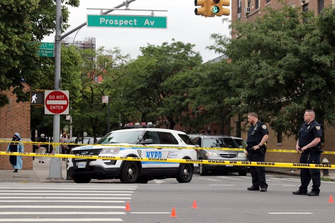 12 June 2021, US, New York City: Police officers investigate the scene at Prospect Avenue in the Longwood-section of the borough, where a person was shot by a gunman in front of St. Anthony of Padua Church. Photo: G. Ronald Lopez/ZUMA Wire/dpa