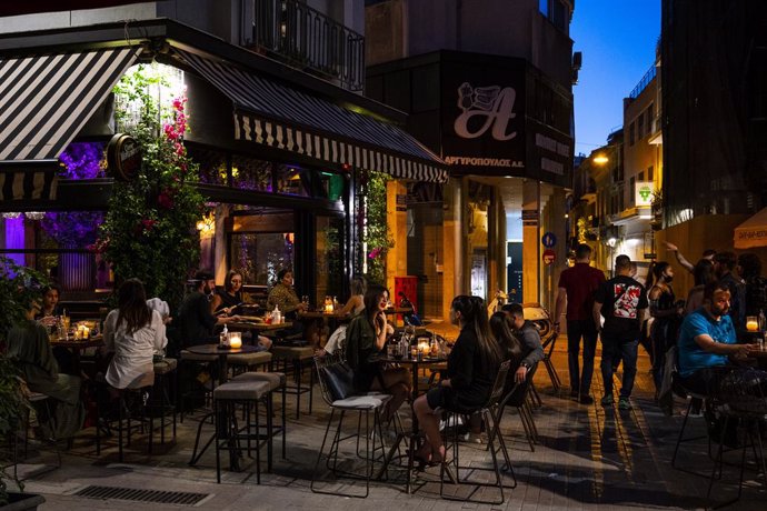 Archivo - 12 May 2021, Greece, Athens: Guests sit in the terrace of a bar in Athens. Taverns, bars and cafés have reopened in Greece as the country eases the measures imposed to curb the spread of Coronavirus pandemic. Photo: Angelos Tzortzinis/dpa