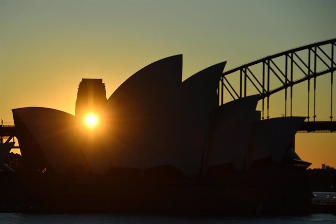 The sun is seen setting through the Sydney Harbour Bridge pylon lookout and through the sails of the Sydney Opera House in Sydney, Monday, July 5, 2021. (AAP Image/Mick Tsikas) NO ARCHIVING