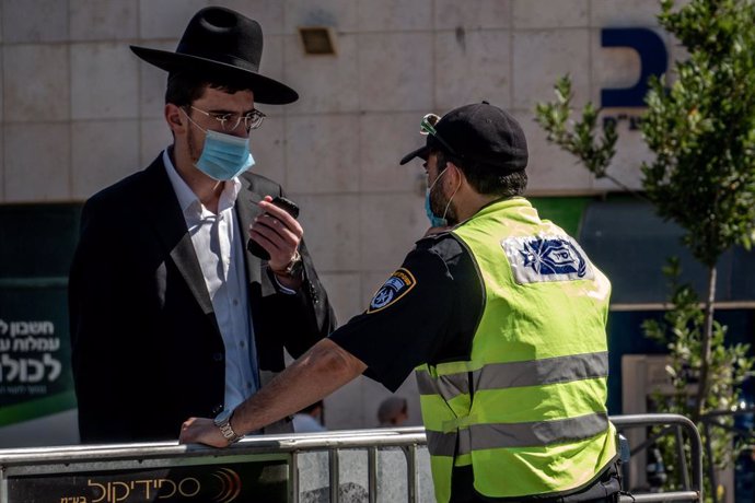 Archivo - Un policía de Israel junto a un hombre durante la pandemia de coronavirus