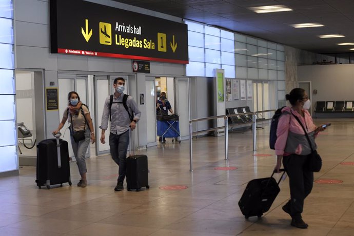 Pasajeros procedentes de un vuelo con origen Gran Bretaña llegan a la terminal T1 del Aeropuerto Adolfo Suárez Madrid-Barajas en Madrid (España). 