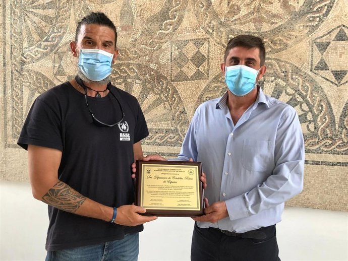 El delegado de Cooperación al Desarrollo de la Diputación de Córdoba, Ramón Hernández (dcha.), recibe la placa de reconocimiento de manos de Antonio García, en representación de Bomberos Unidos Sin Fronteras.