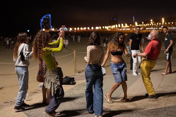 Un grupo de chicas y un señor bailan a pié de playa, a 27 de junio de 2021, en Barcelona, Catalunya (España). Este jueves 24 de junio, en un Consejo de Ministros extraordinario, el Gobierno de España aprobó que las mascarillas dejasen de ser obligatoria