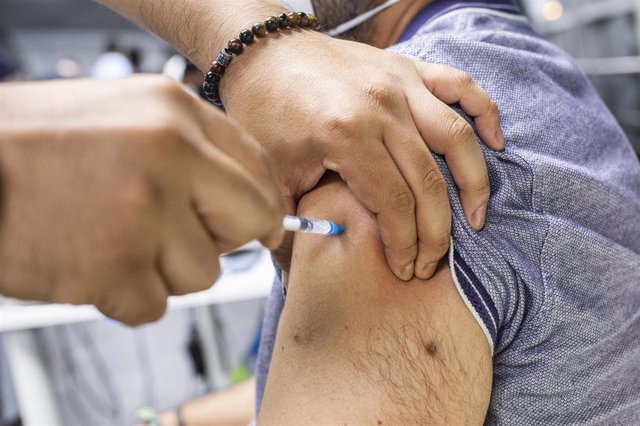 Un sanitario administra una dosis de la vacuna de Pfizer a un hombre en el Wizink Center 