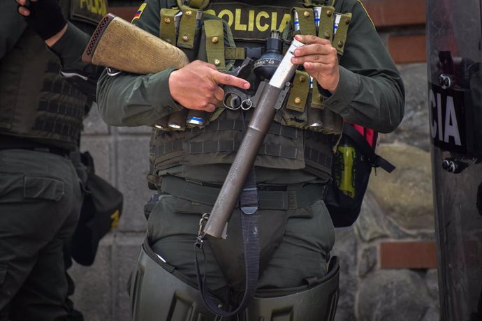 Archivo - Un policía carga su lanzador con un bote de gas lacrimógeno durante los enfrentamientos con los manifestantes tras una protesta contra la brutalidad policial en Colombia