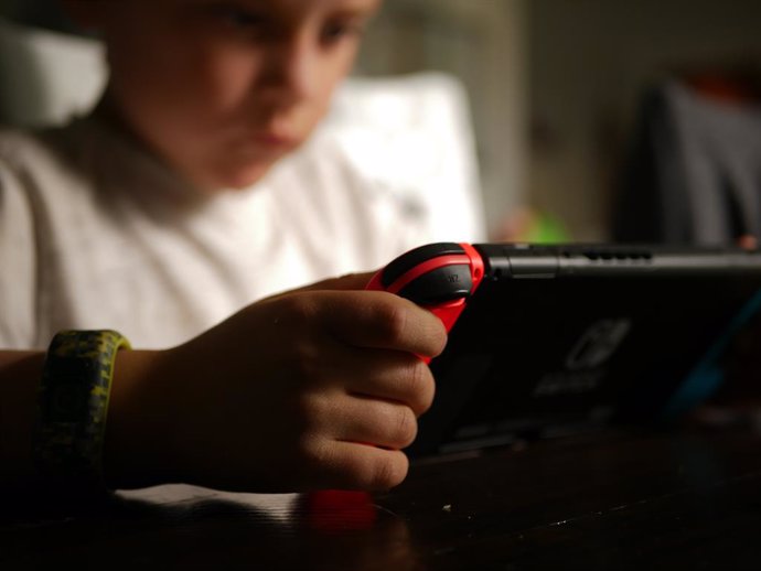 Niño jugando a videojuegos en una consola.