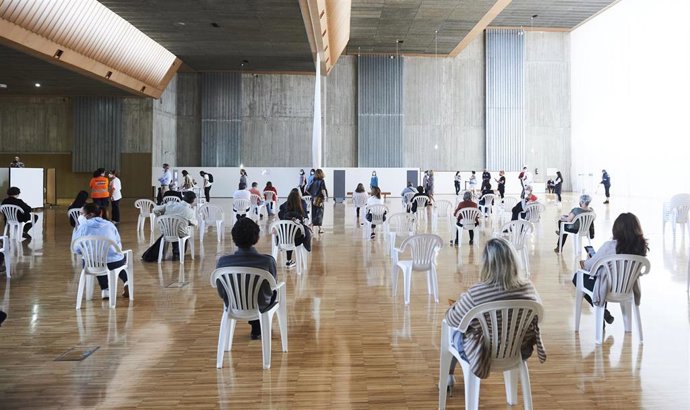 Archivo - Varias personas, en un dispositivo de vacunación masiva frente al Covid-19, en el Palacio de Exposiciones y Congresos de Santander