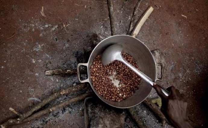 Archivo - Una mujer desplazada interna tuesta cacahuetes en el campamento para personas desplazadas de Cesacoba, cerca de Bangassou, en la República Centroafricana.