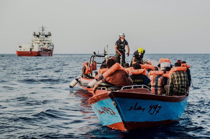 HANDOUT - 04 July 2021, Italy, ---: The helpers approach a small boat with migrants in their rubber dinghy in the Mediterranean Sea. The Ocean Viking rescue vessel has pulled 67 people from the central Mediterranean Sea, SOS Mediterranee the private org